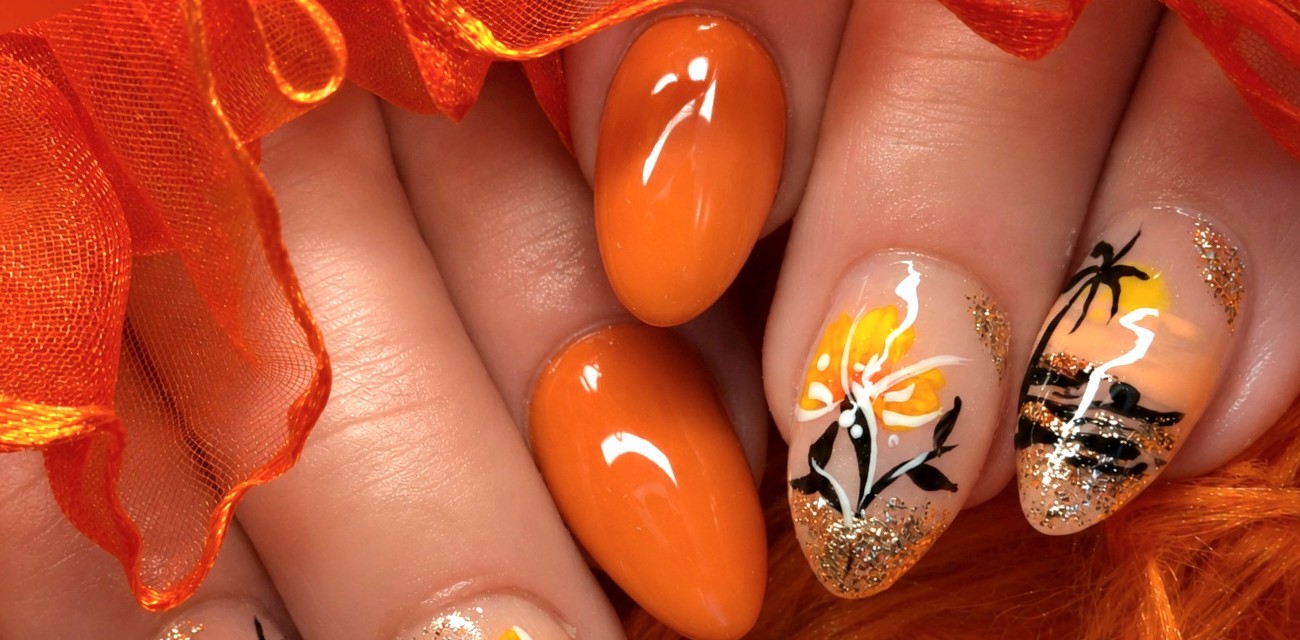 Oranje nagels, een met een bloem en een met een palmboom, op oranje tule