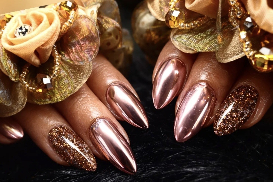 Spitse nagels in rosé chrome en koperkleurige glitter, op zwart bont