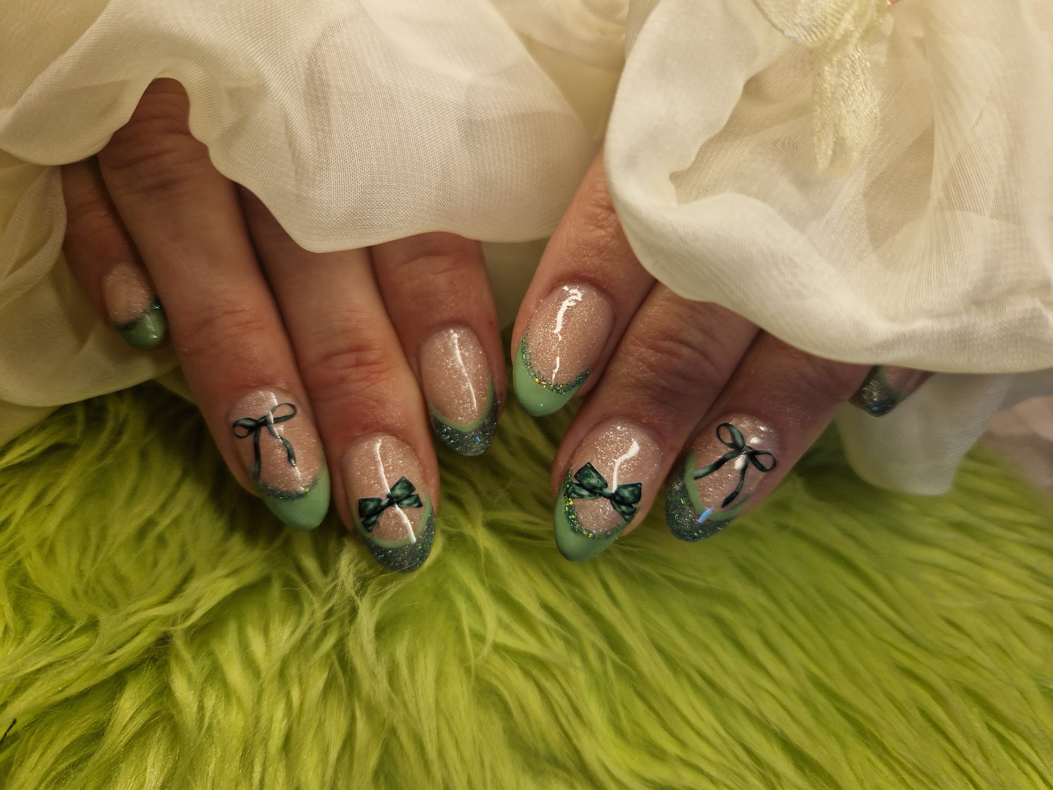 Mintgroene French tips met zwarte strikjes, op groen bont